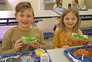 kids holding up microgreens salad